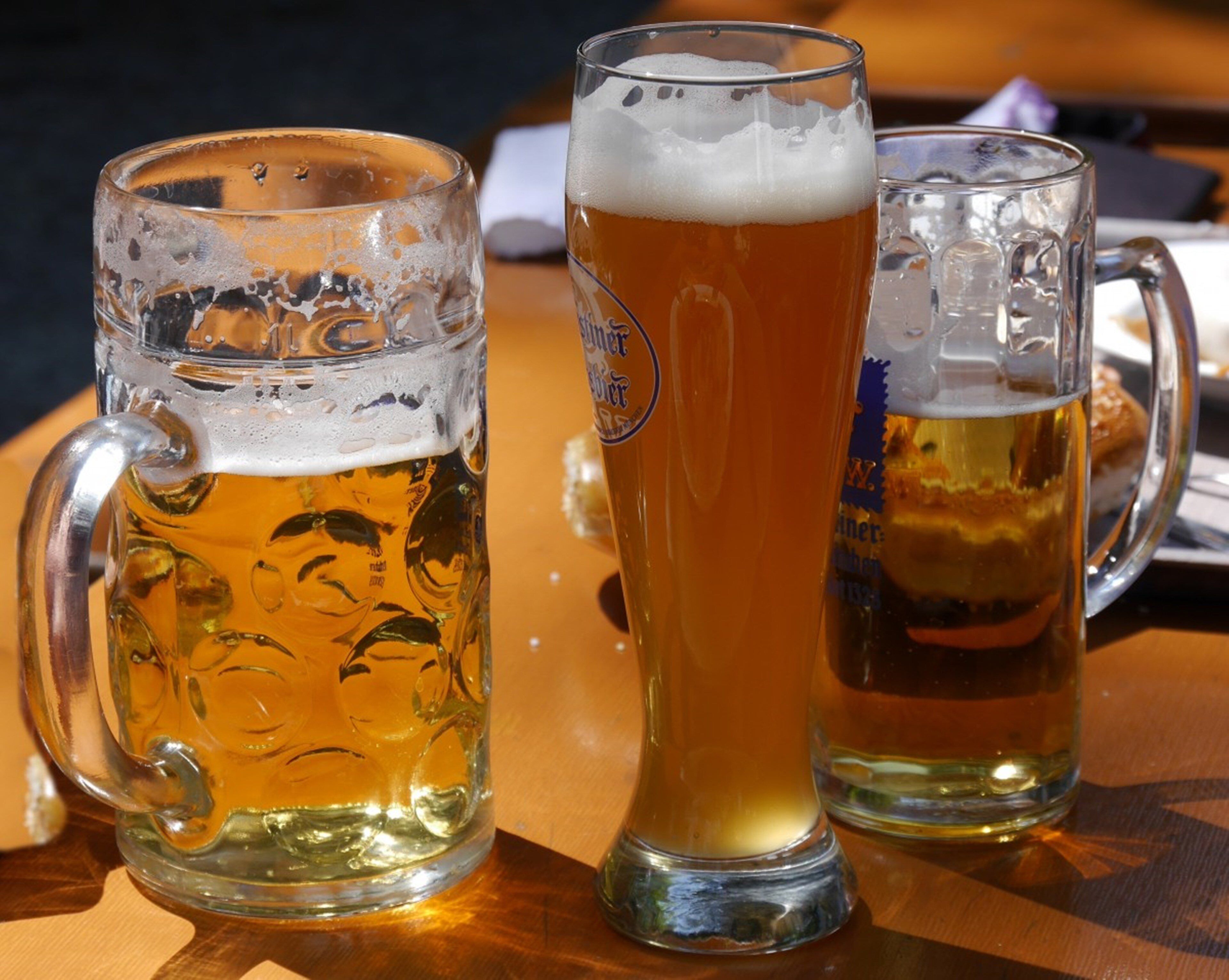 Trois chopes de bière sur une table en bois.