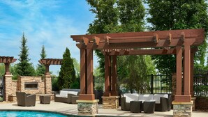A poolside area with a pergola, stone pillars, and outdoor seating. - Residence Inn Nashville SE/Murfreesboro (Murfreesboro)