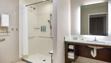 Une salle de bain moderne avec une douche à l’italienne, un meuble-lavabo avec un miroir et un porte-serviettes.