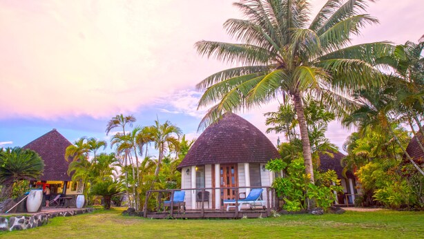 A tropical resort with thatched-roof huts, palm trees, and a grassy lawn. - Le Lagoto Resort & Spa (Fagamalo)