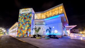 A modern hotel with a colorful exterior and a well-lit entrance. - Nicholas Color Hotel (Ayia Napa)