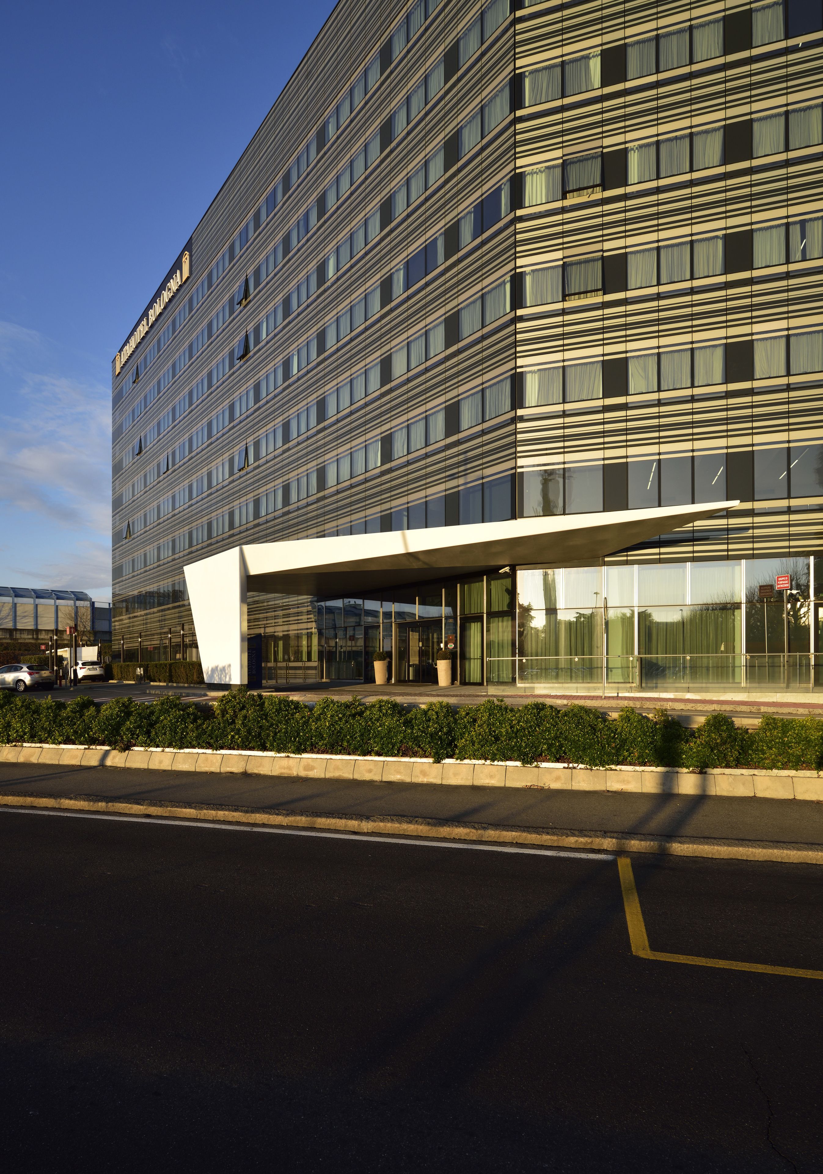 A modern building with a glass facade and a covered entrance.