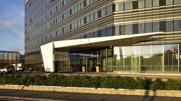 A modern building with a glass facade and a covered entrance.