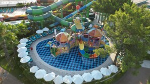 A water park with a checkered pool, slides, and play structures. - Crystal Flora Pearl Collection (Kemer)