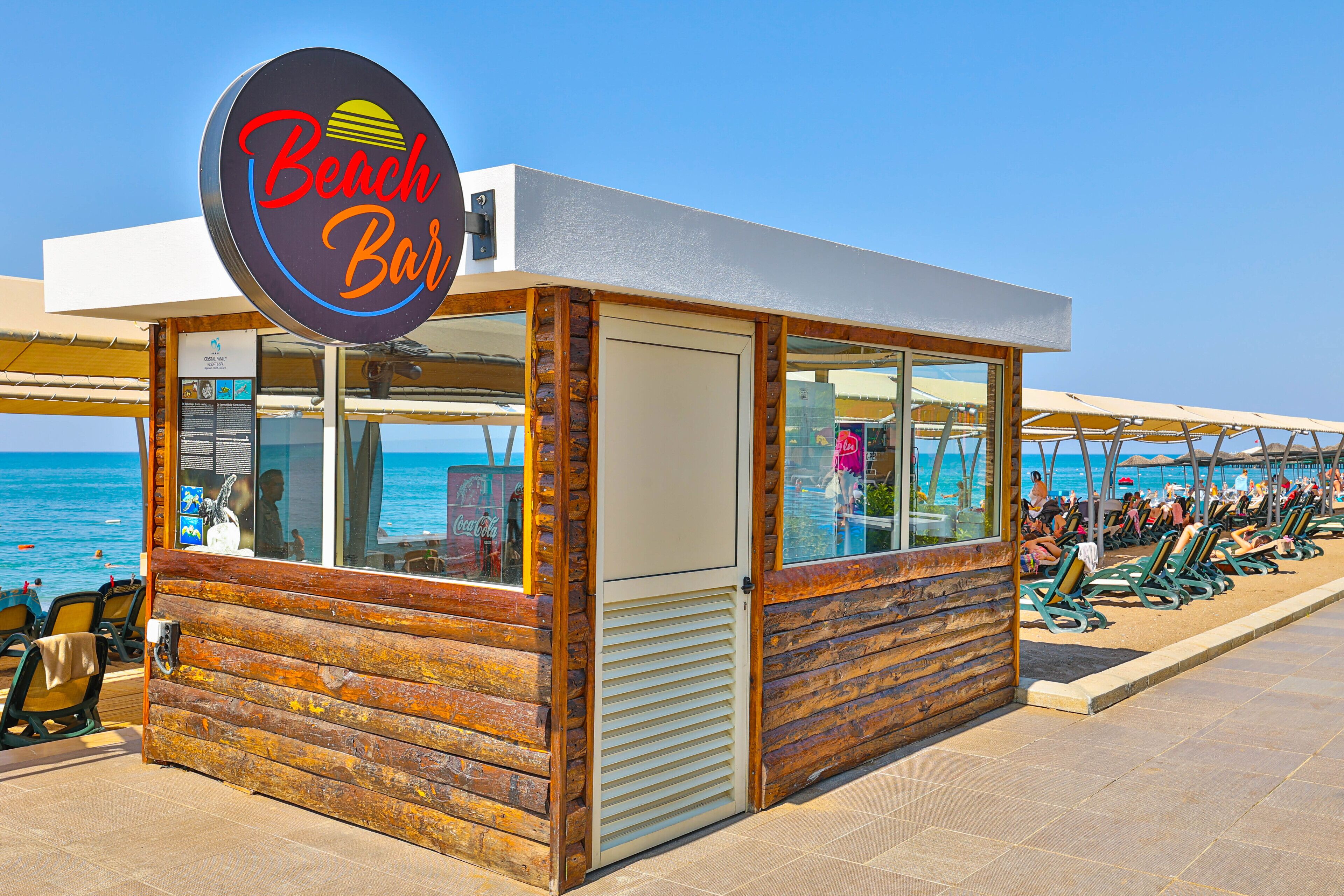 Un bar de plage avec une façade en bois, de grandes fenêtres et une enseigne.