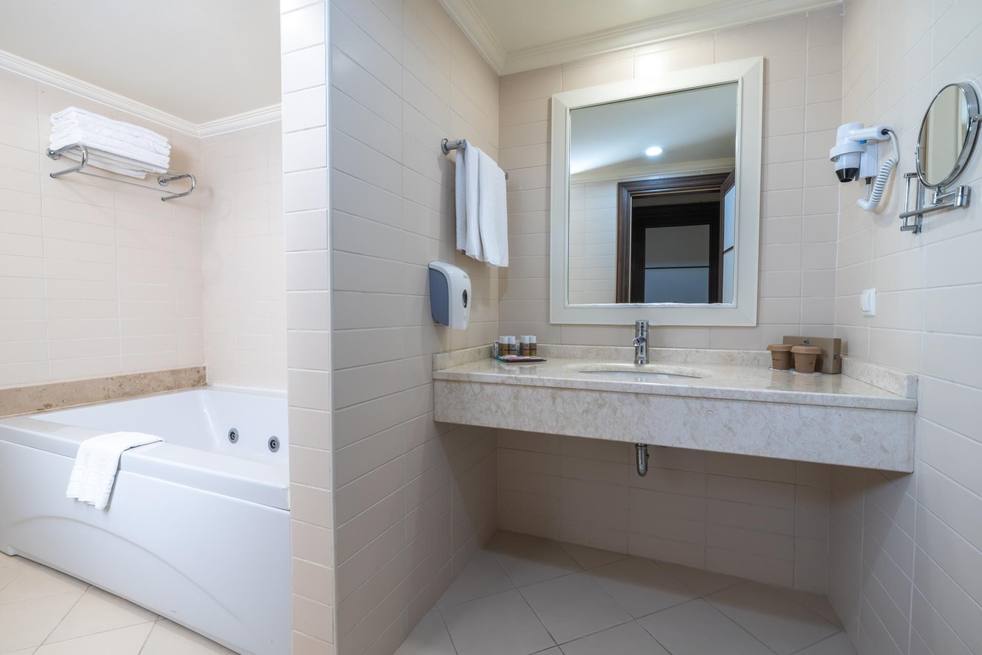 Un bagno moderno con una vasca, un lavabo, uno specchio e un portascopevoli.