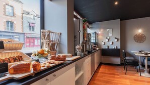 Una cocina moderna con un ventanal grande, suelo de madera y un comedor con mesa y sillas.