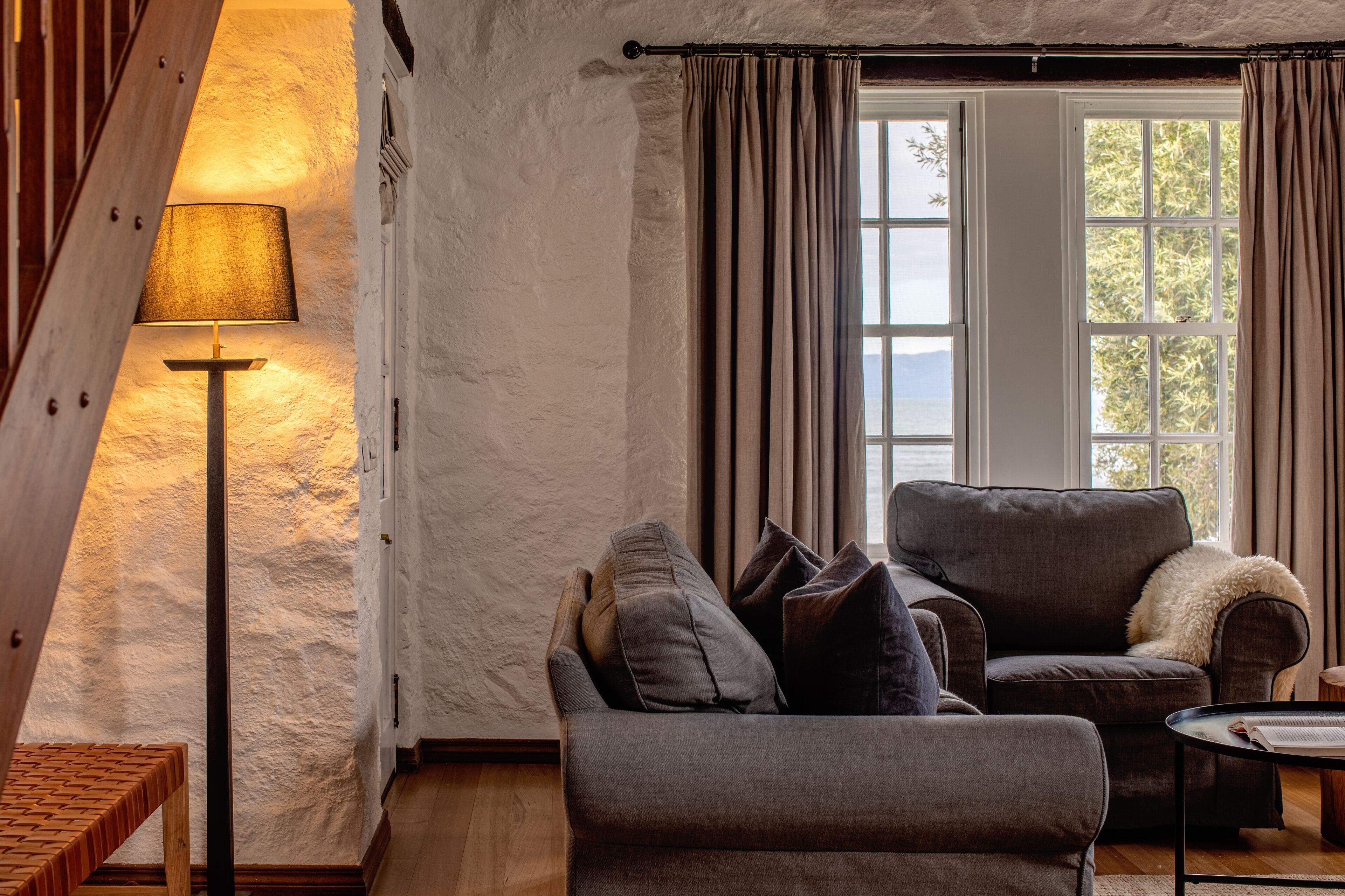 A cozy living room with a sofa, a small table, and a lamp.