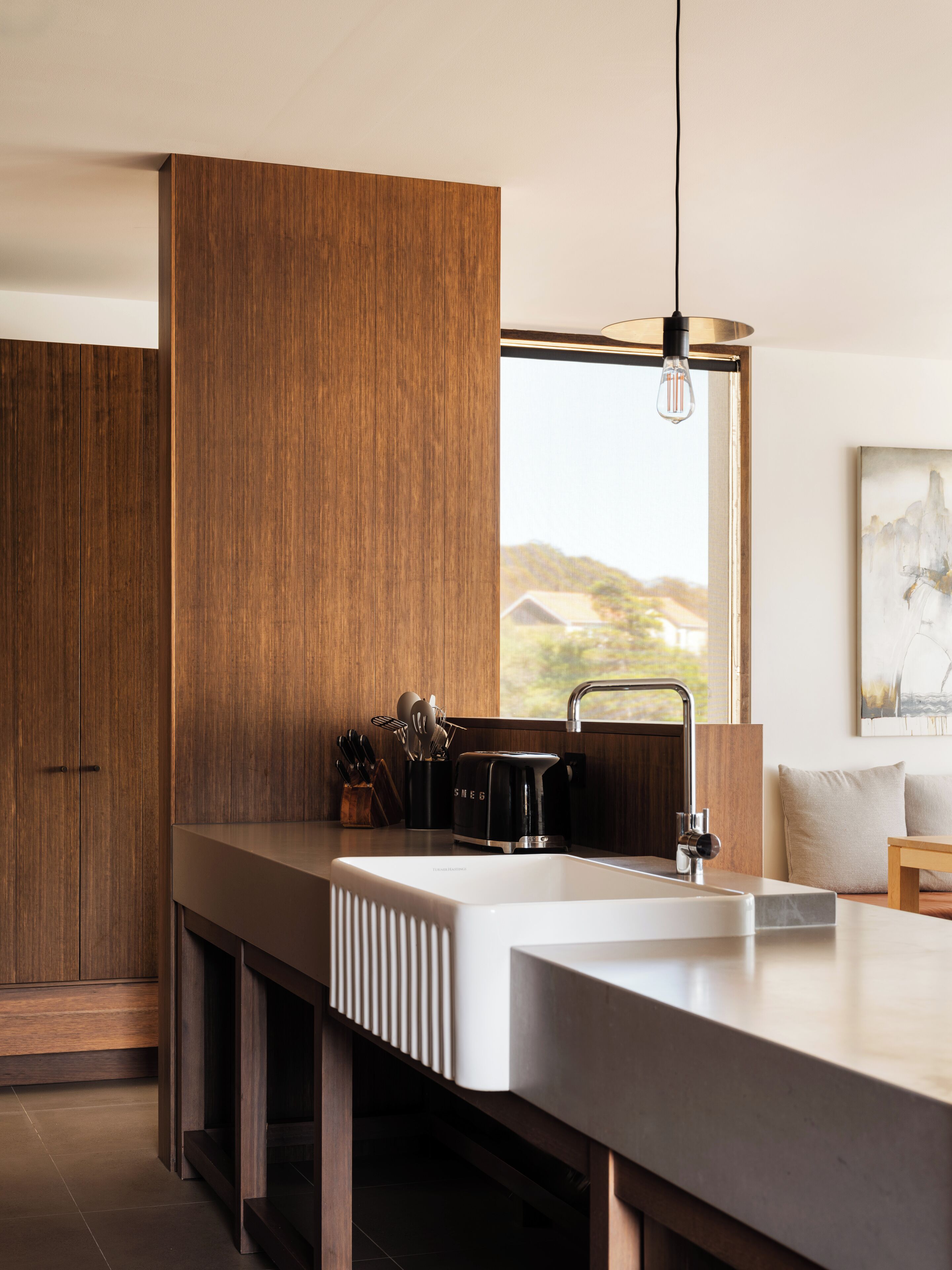 Una cocina moderna con una isla grande, armarios de madera y vista al exterior.