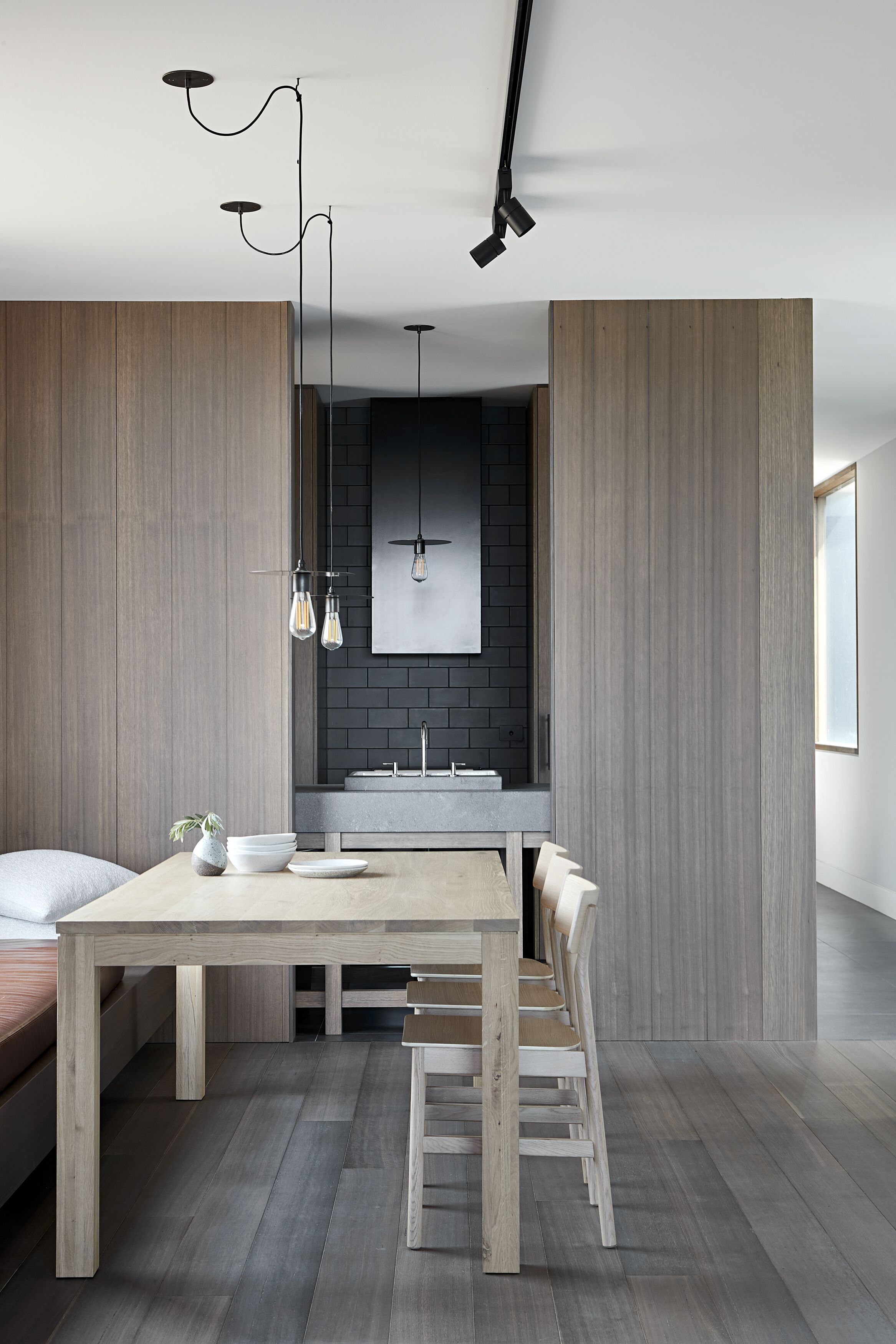 A modern kitchen with a central island, pendant lighting, and a minimalist design.