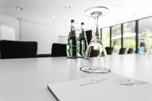Una habitación de hotel moderna con una mesa blanca, un menú y tres copas de vino.