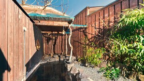 A traditional Japanese garden with a koi pond, wooden fences, and bamboo plants. - Manten no Hoshi (Hakone)