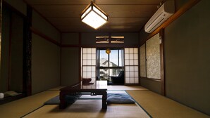 A traditional Japanese room with tatami flooring, a low wooden table, and sliding doors leading to a balcony. - Manten no Hoshi (Hakone)