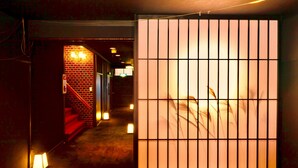 A corridor with a traditional sliding door, a staircase, and a brick wall. - Manten no Hoshi (Hakone)