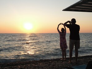 A sunset over the ocean with two people forming a heart shape. - Crystal De Luxe Comfort Collection - All inclusive (Kemer)