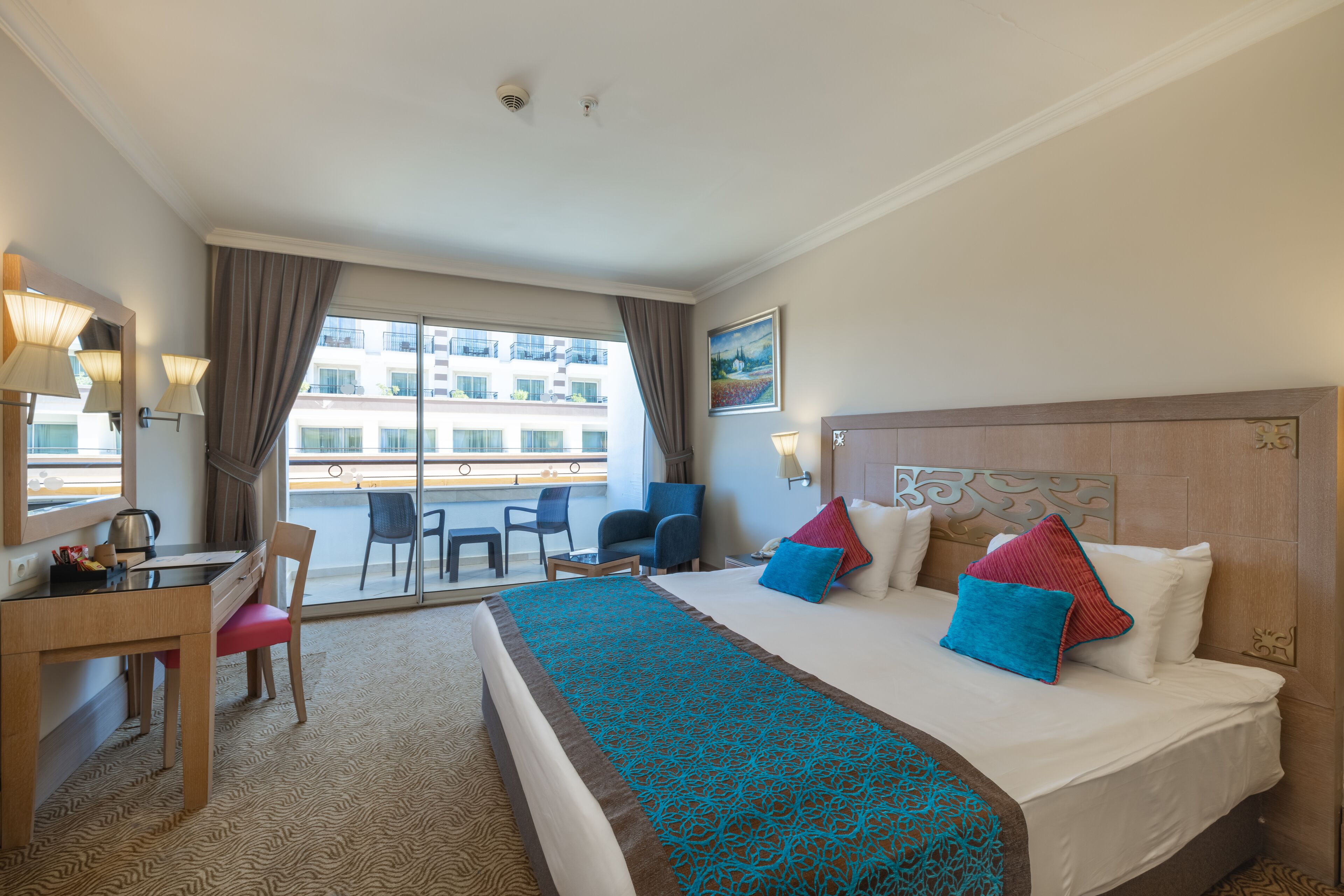 Una habitación de hotel con una cama, un escritorio, una silla y vistas al exterior.