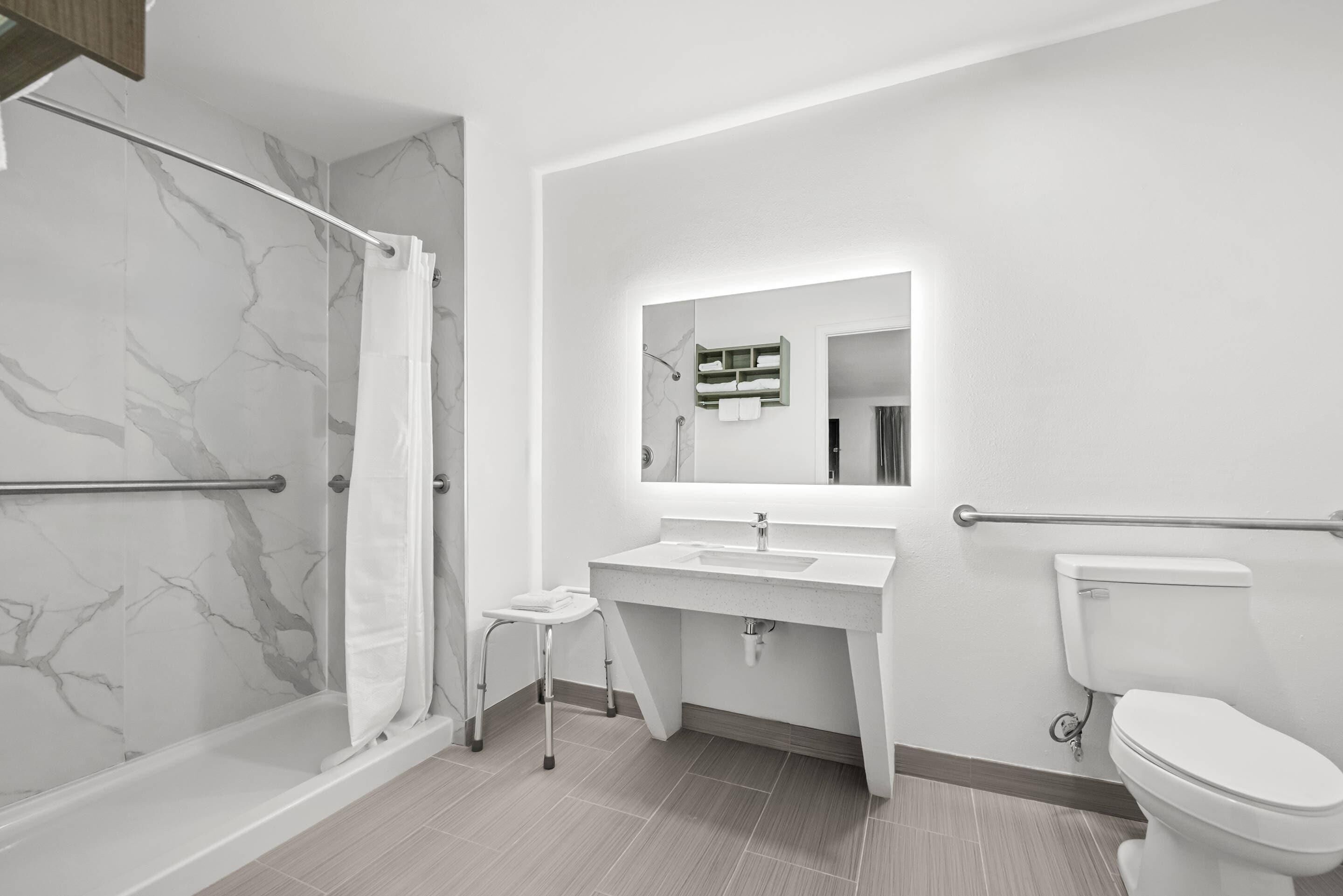 A modern bathroom with a shower, toilet, and sink.