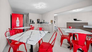 A modern kitchen with white cabinets and a red Coca-Cola logo on the wall. - Econo Lodge Biloxi Beach (Biloxi)