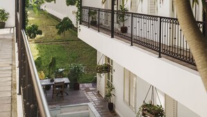 A modern building with a pool, outdoor seating, and lush greenery. - Brown Feather Batu Belig (Keroboken Kelod)