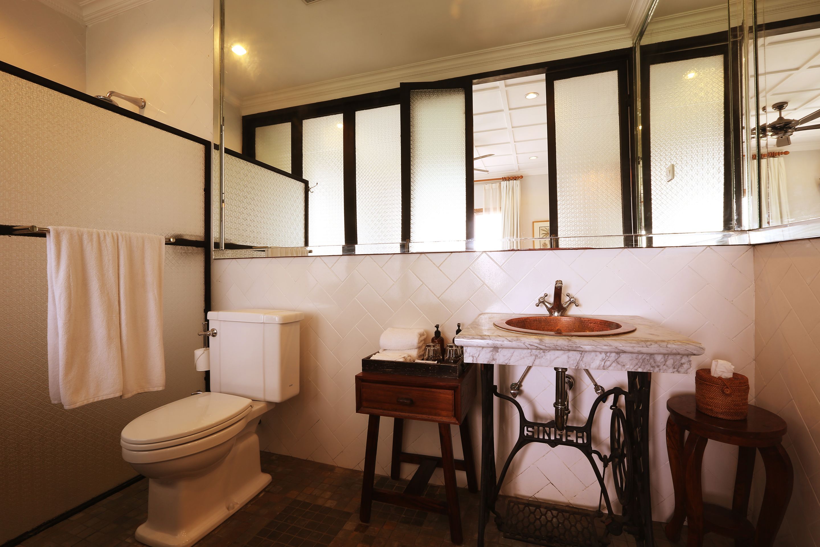 A bathroom with a toilet, sink, and mirror.