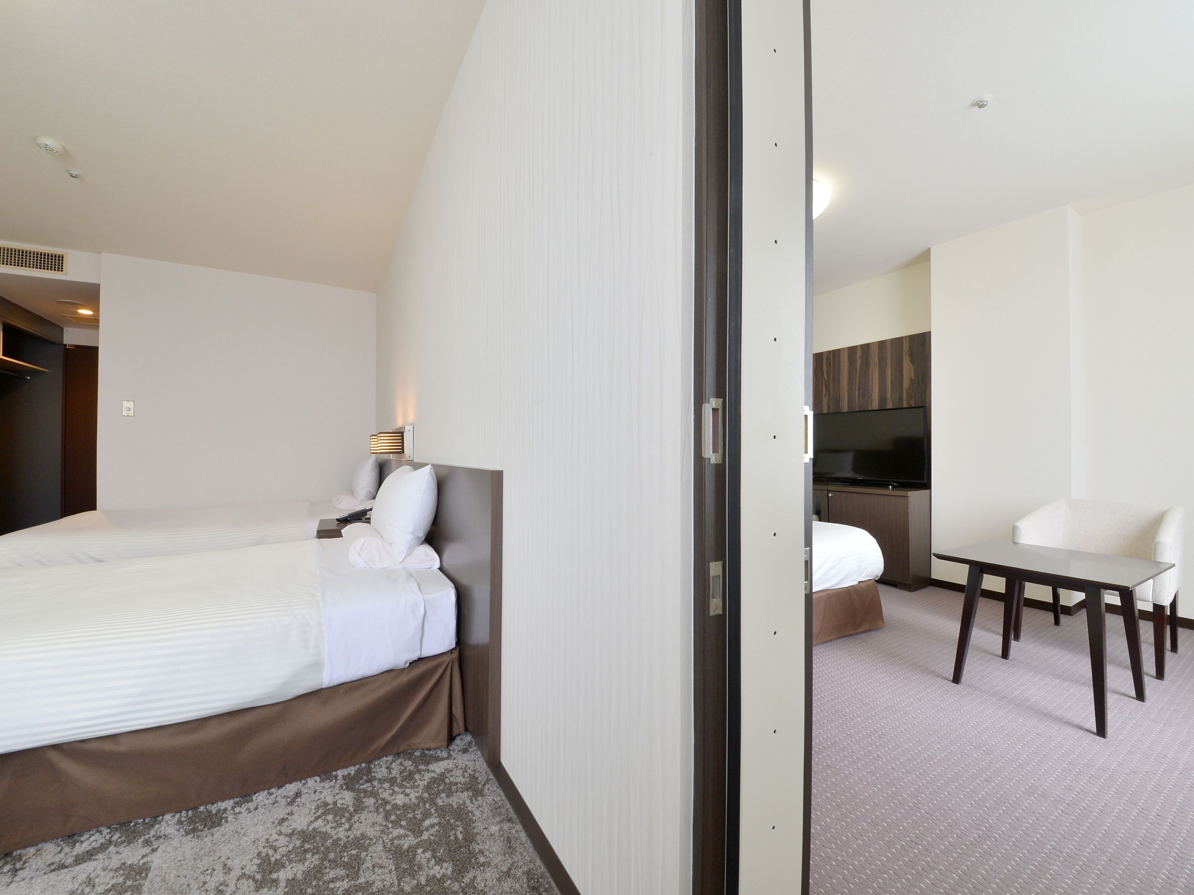 Una habitación de hotel con cama, escritorio y televisión.