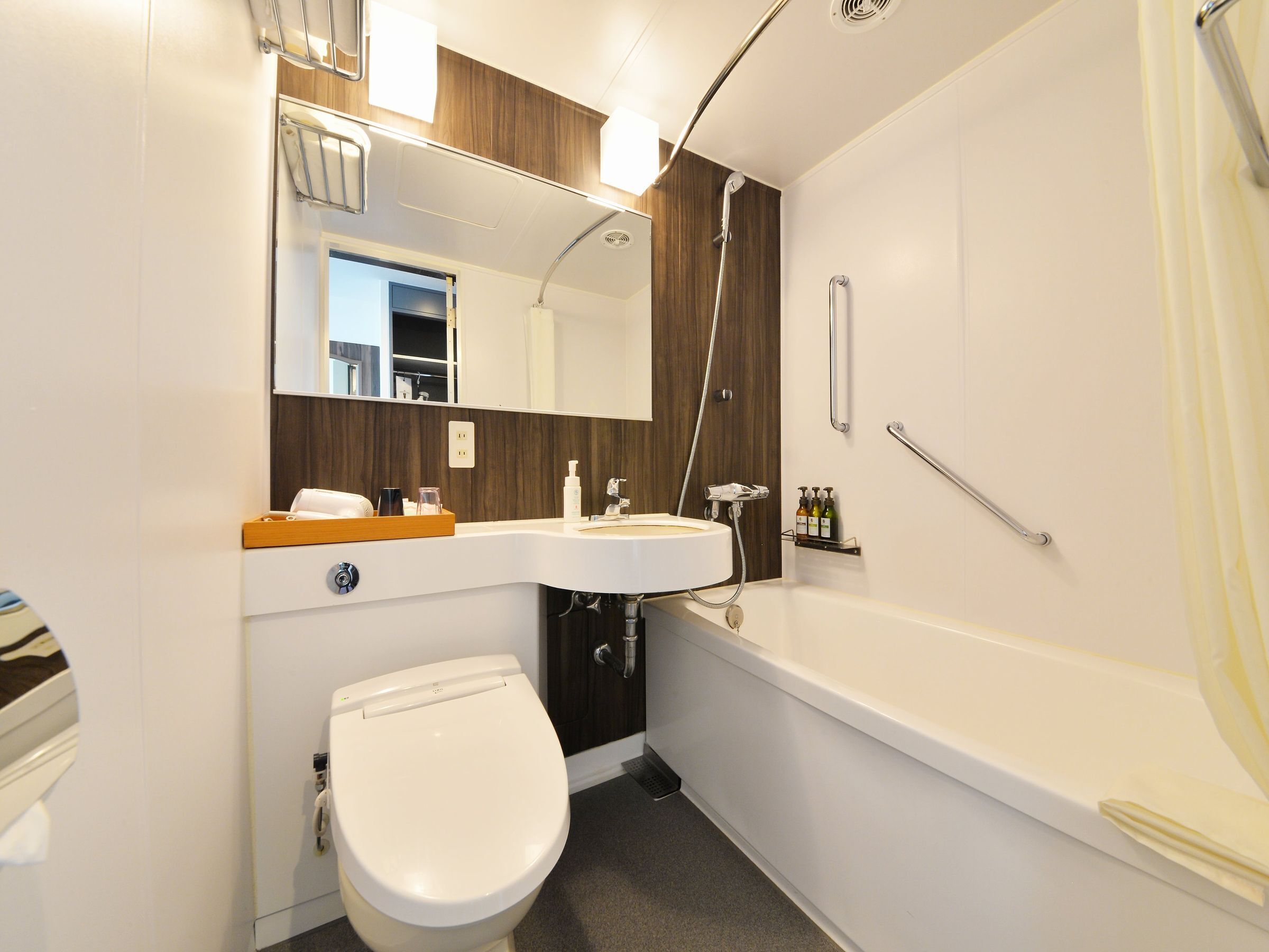 Een moderne badkamer met een wit toilet, een wastafel en een bad.