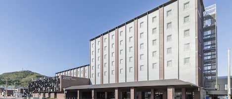 Et moderne hotel med fladt tag, flere etager og en markant indgang.