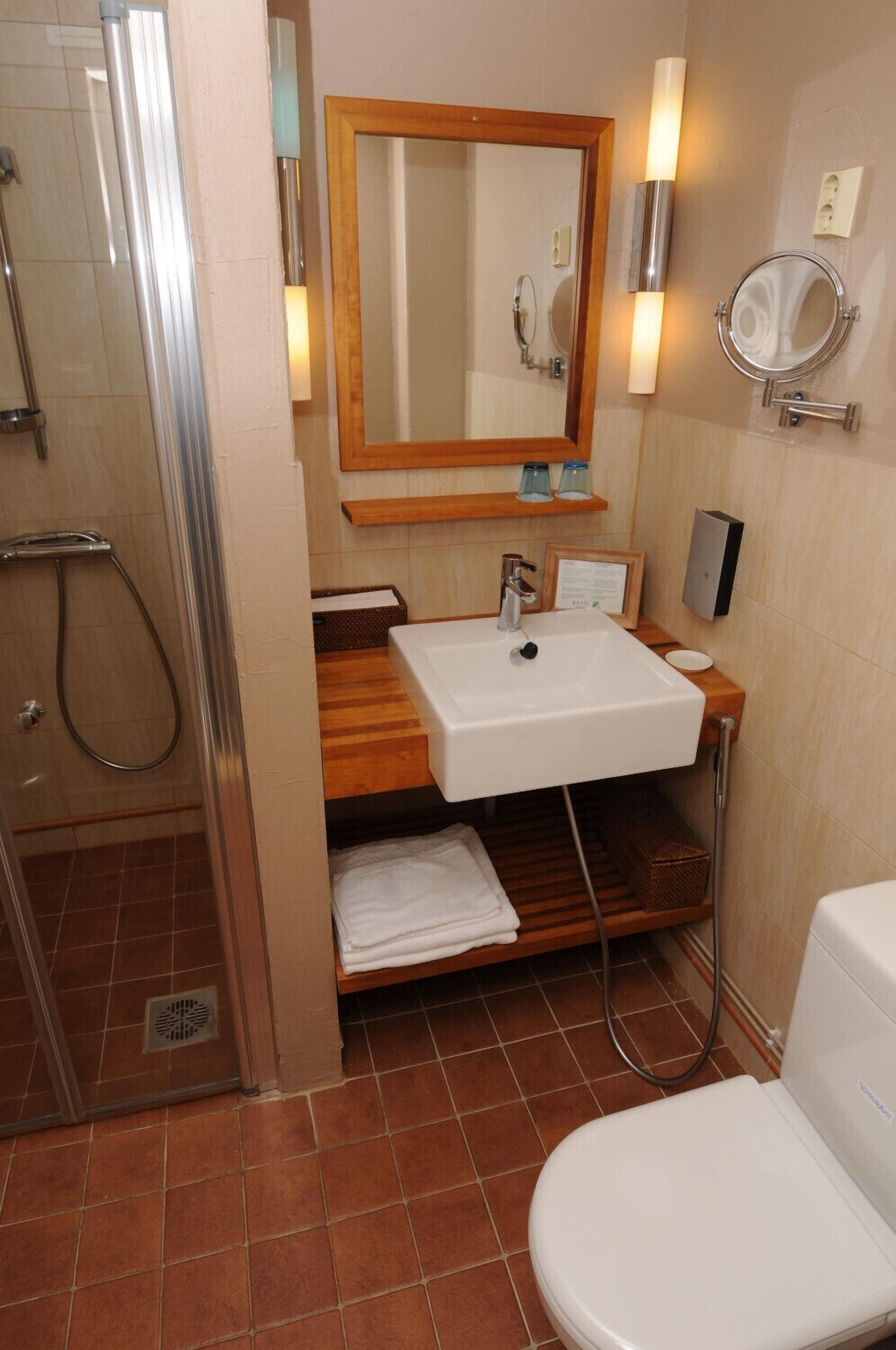 Un baño con ducha, lavamanos e inodoro.