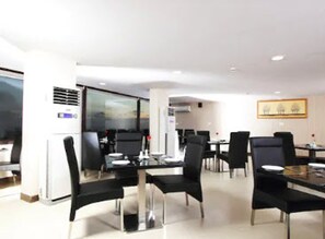 Enjoy a meal in this stylish dining area with a large window offering a view of the outdoors.