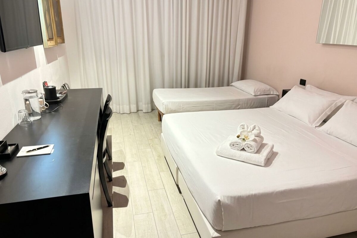 Una habitación de hotel con cama, escritorio y televisor.