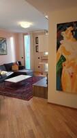 Una sala de estar moderna con un sofá, una mesa de centro y un cuadro grande en la pared.