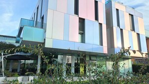 A modern building with a multi-story structure, large windows, and a flat roof. - Blue Shades Aparthotel (Pisa)