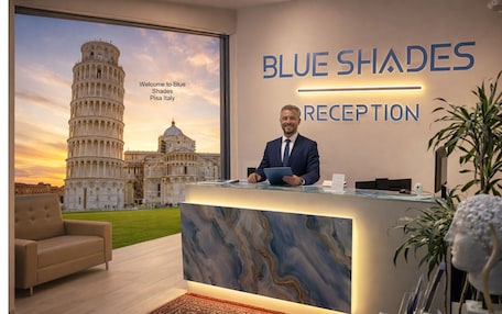 A reception desk with a marble top, a man in a suit, and a view of the Leaning Tower of Pisa.