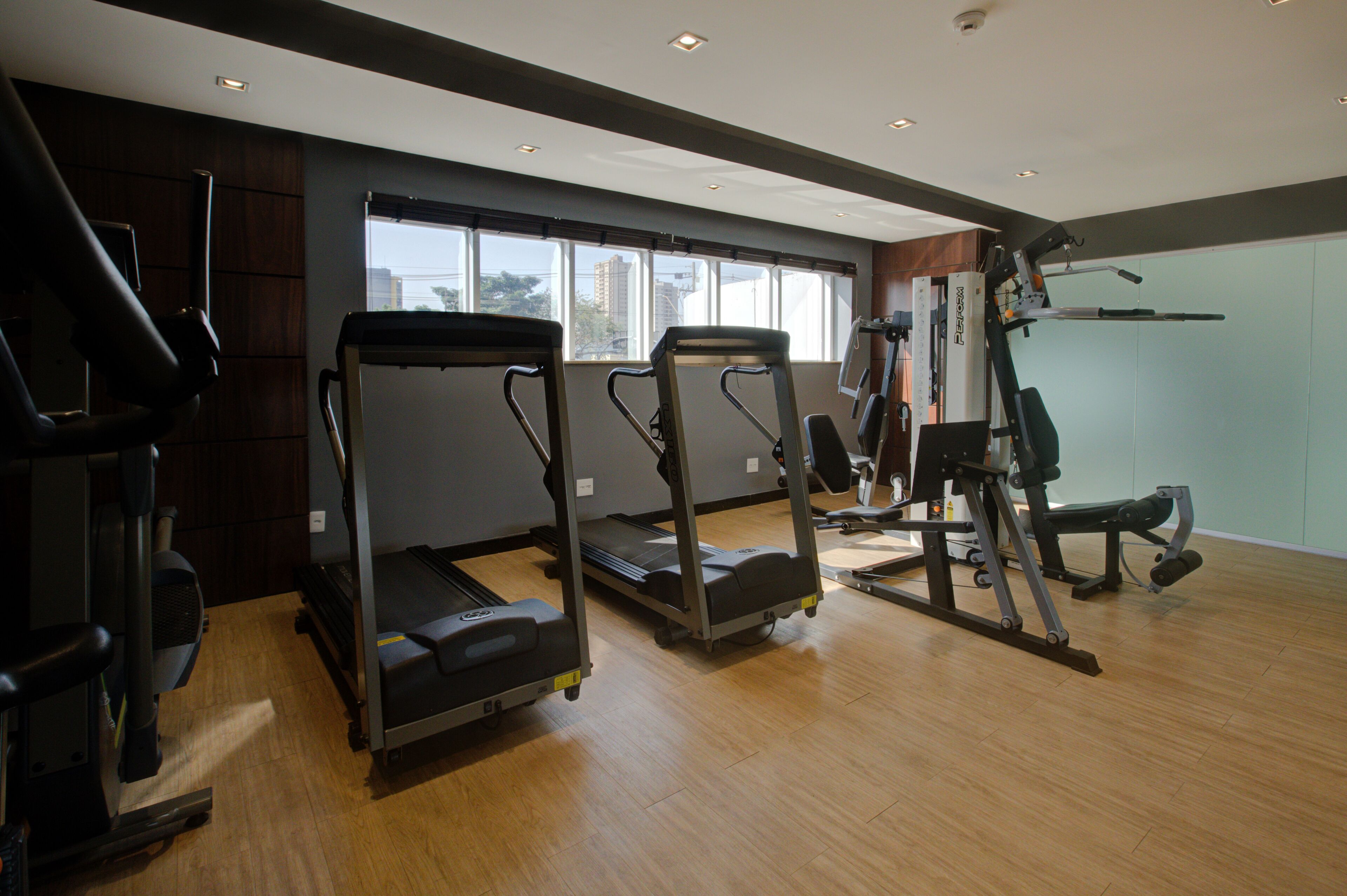 Une salle de sport équipée de tapis de course, d’un vélo d’appartement et d’appareils de musculation.