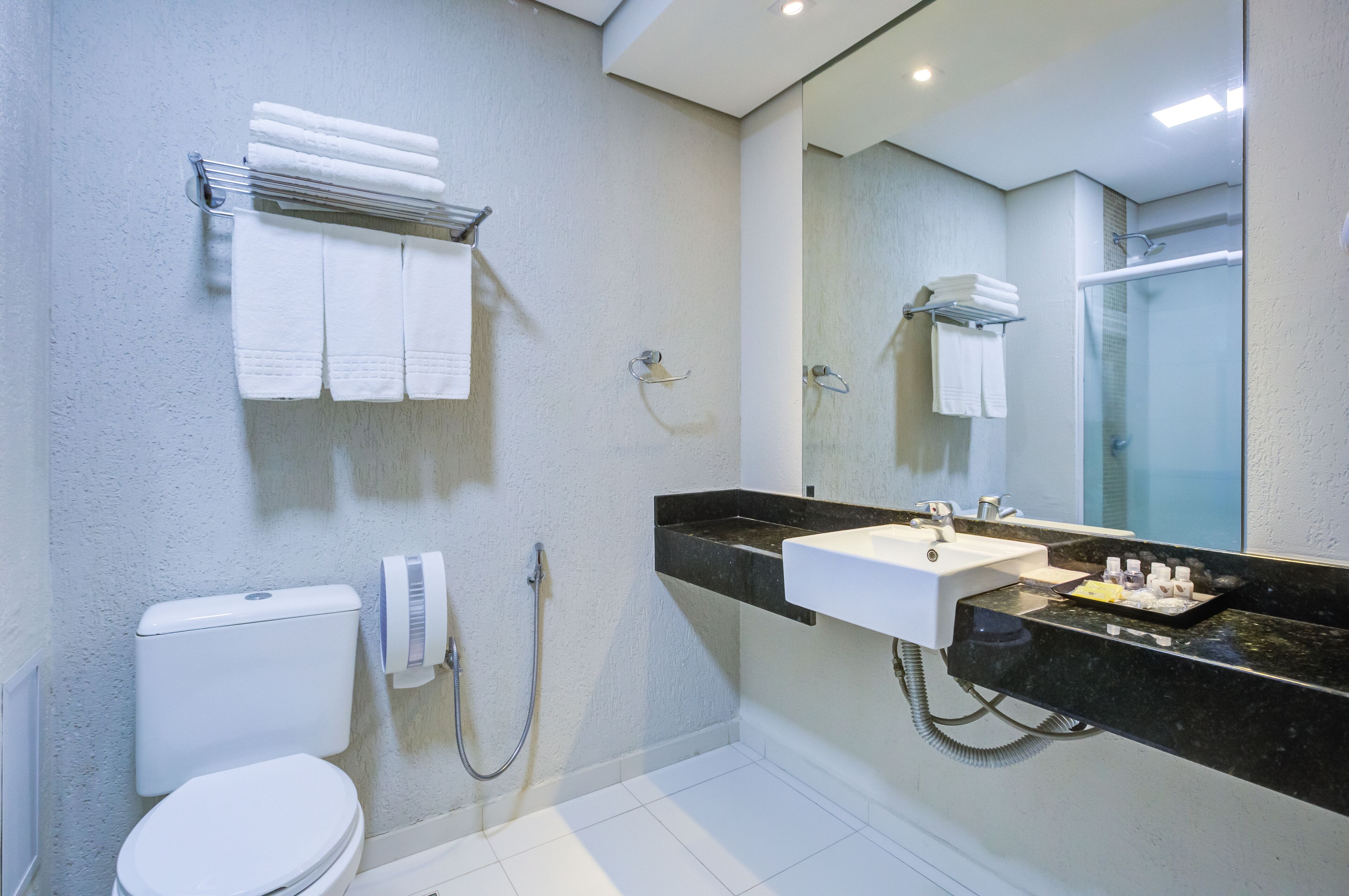 A modern bathroom with a toilet, sink, and shower.