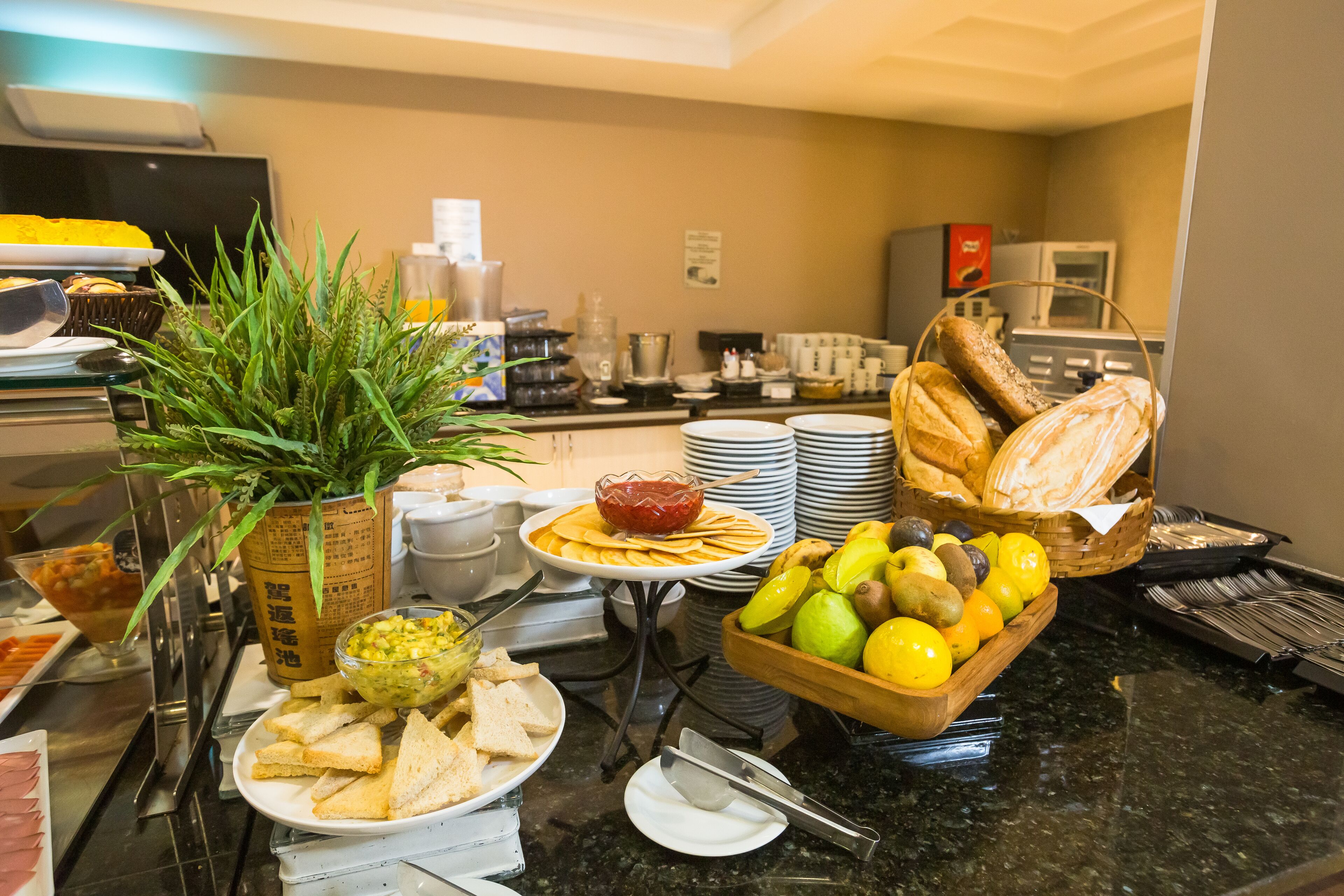 Ein Buffet mit verschiedenen Speisen, darunter Brot, Früchte und eine Salatschüssel.