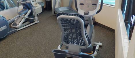 A gym with treadmills, an elliptical, and a stationary bike.
