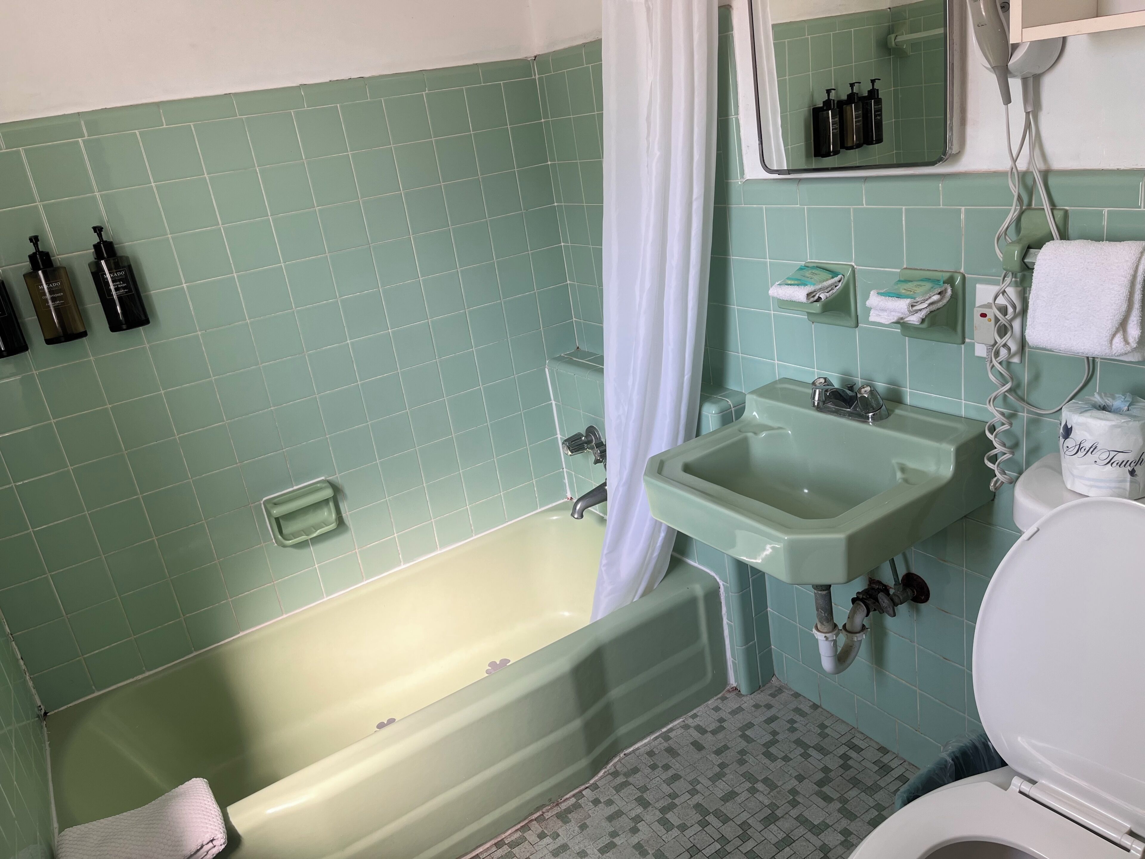 Un baño con bañera, lavamanos e inodoro.
