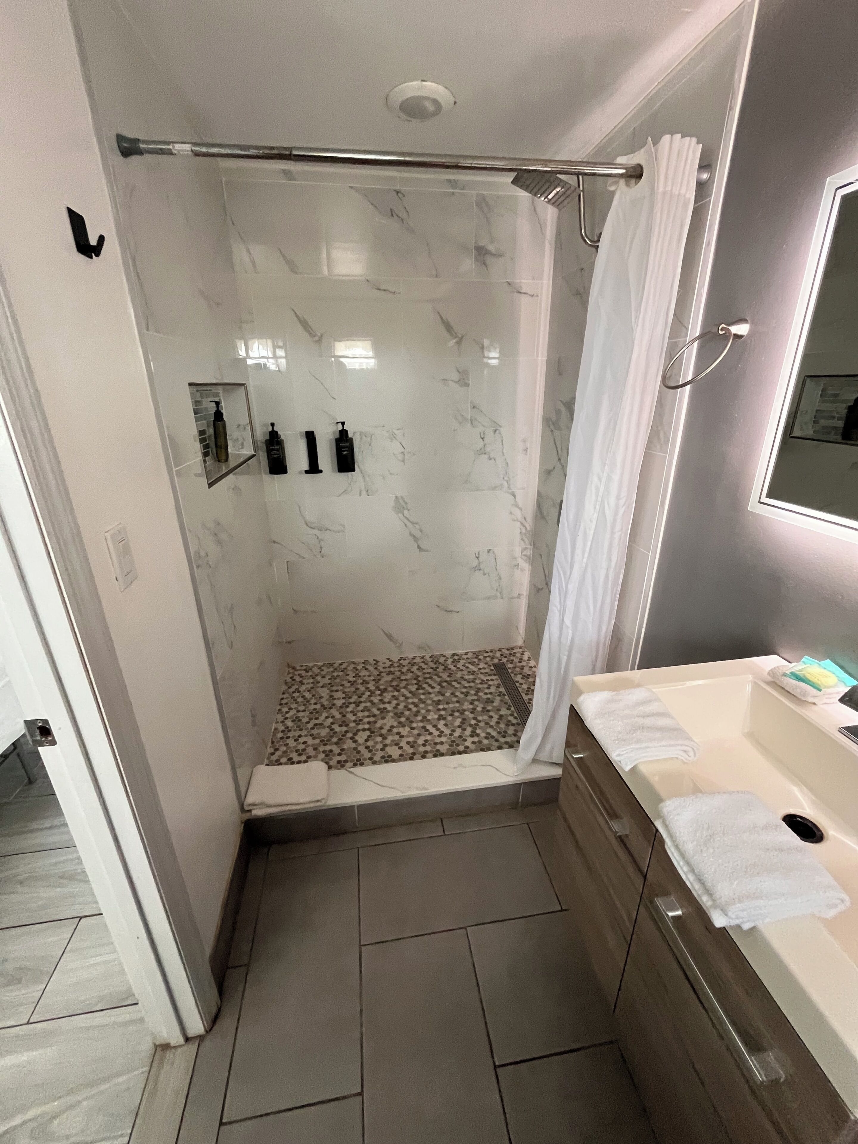 Deluxe kamer, 1 kingsize bed | Badkamer | Een bad/douchecombinatie, een haardroger, handdoeken, zeep