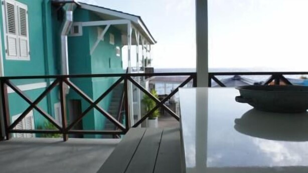 A balcony with a view of the sea, a white table, and a black pot. - Sand Castle Motel (Daytona Beach Shores)