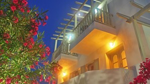A building with a balcony, a staircase, and a light fixture. - Hotel Rigas (Milos)