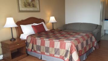 A hotel room with a bed, two bedside lamps, a nightstand, and a framed picture on the wall.