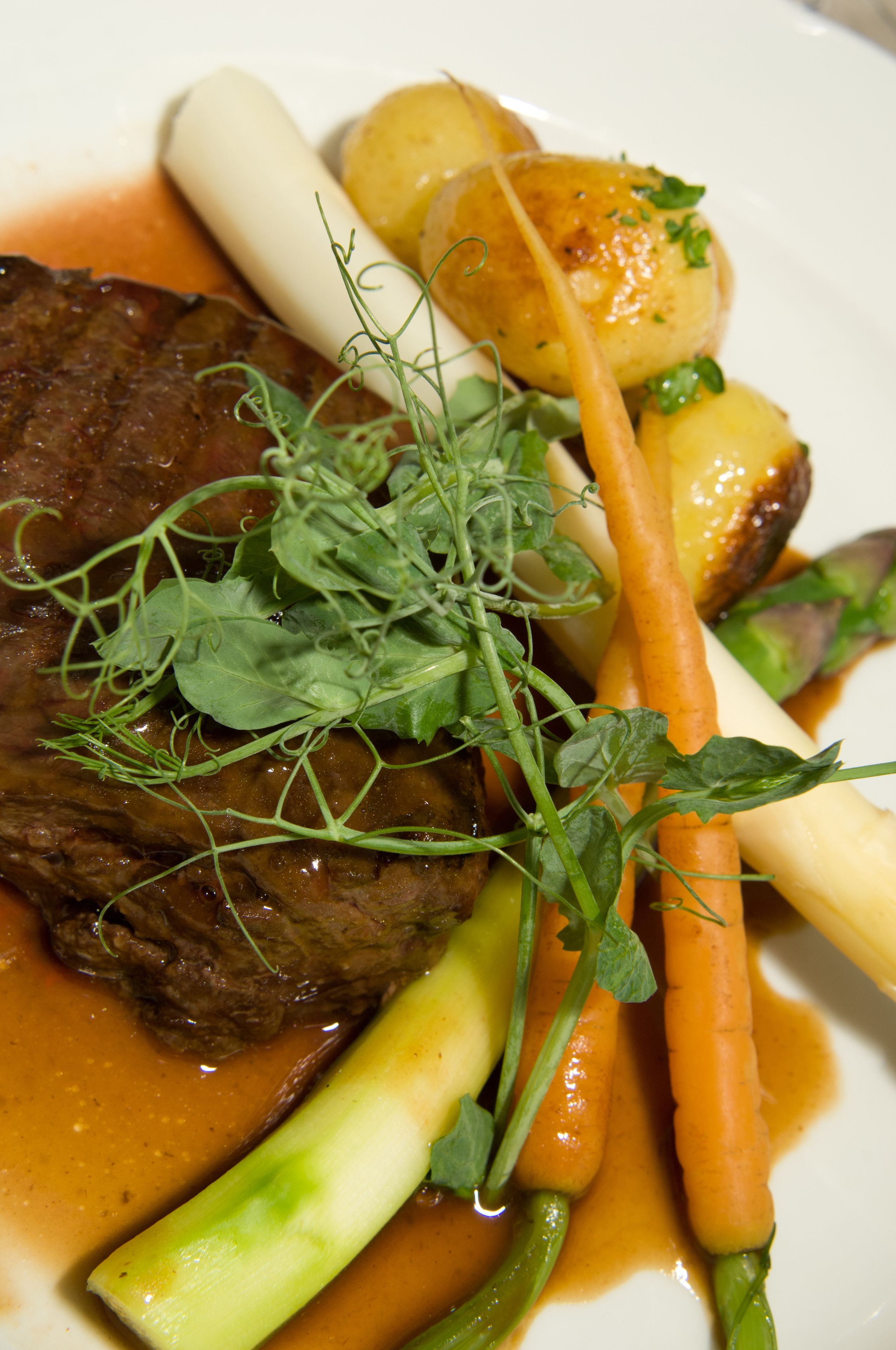 A plate of food with a beef steak, carrots, and potatoes.