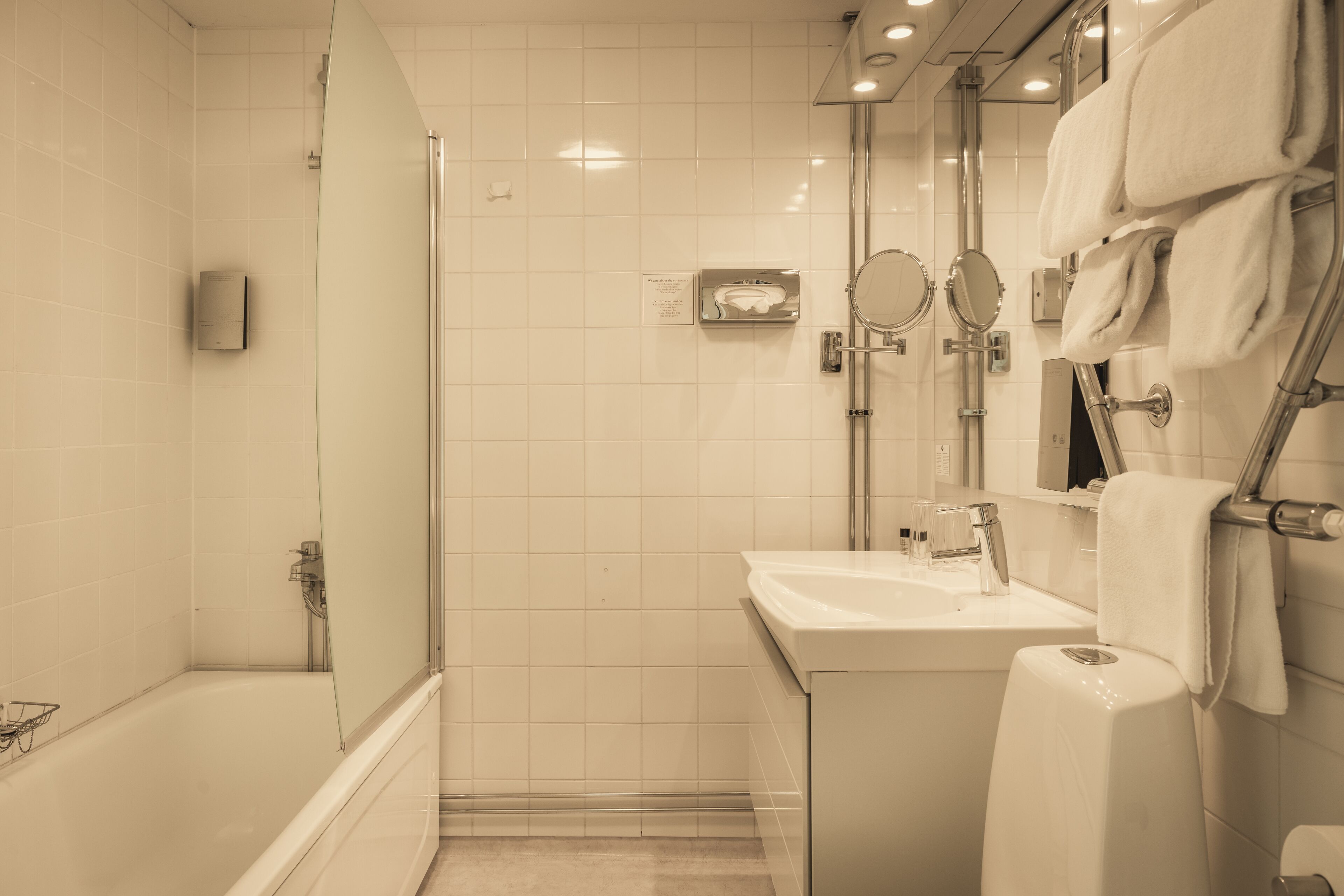 Une salle de bain moderne avec une douche à parois de verre, un lavabo blanc et des toilettes.