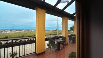 Un balcón con vista al mar y a los barcos, que incluye una mesa y sillas.