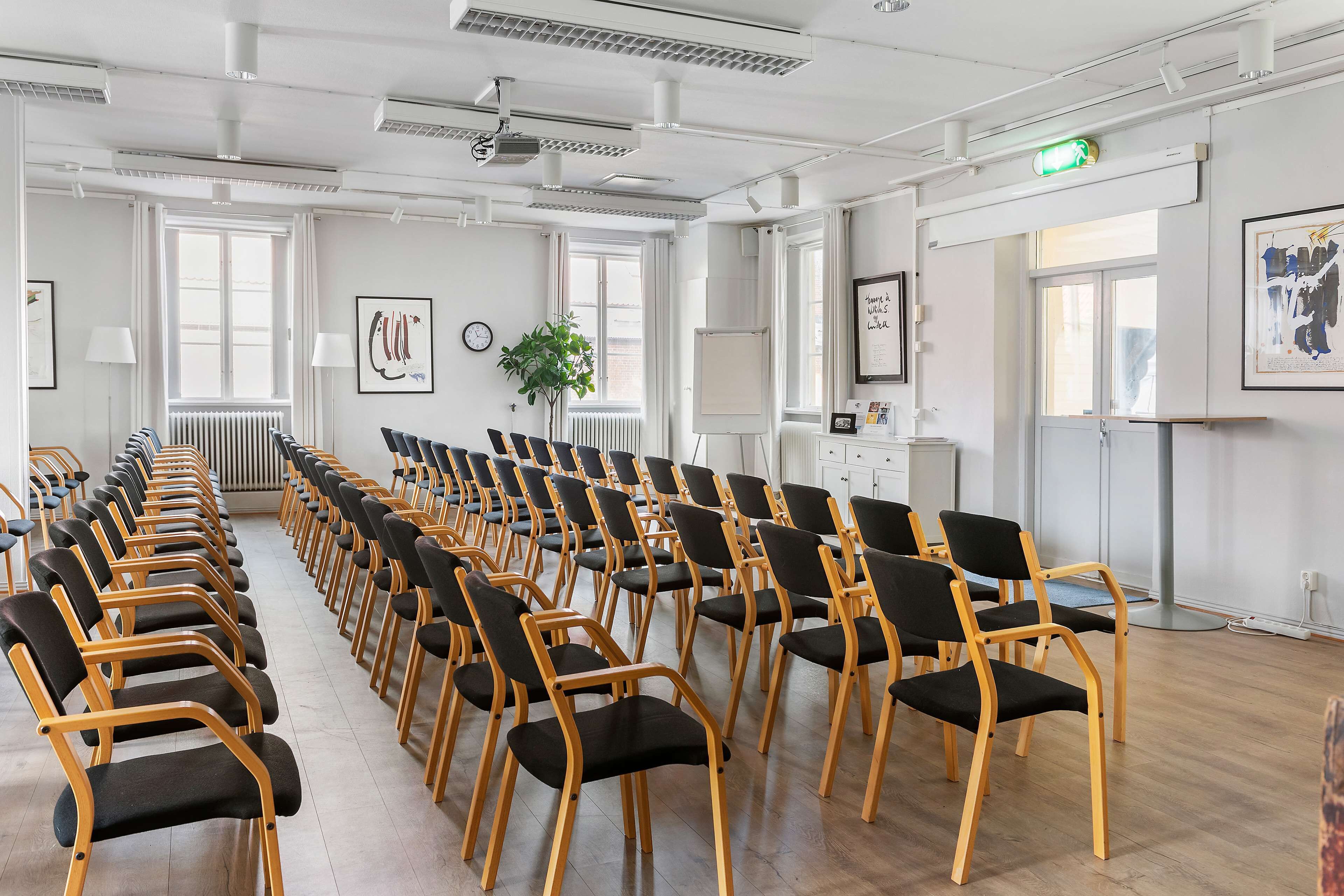 A conference room with rows of chairs, a projector, and a whiteboard.