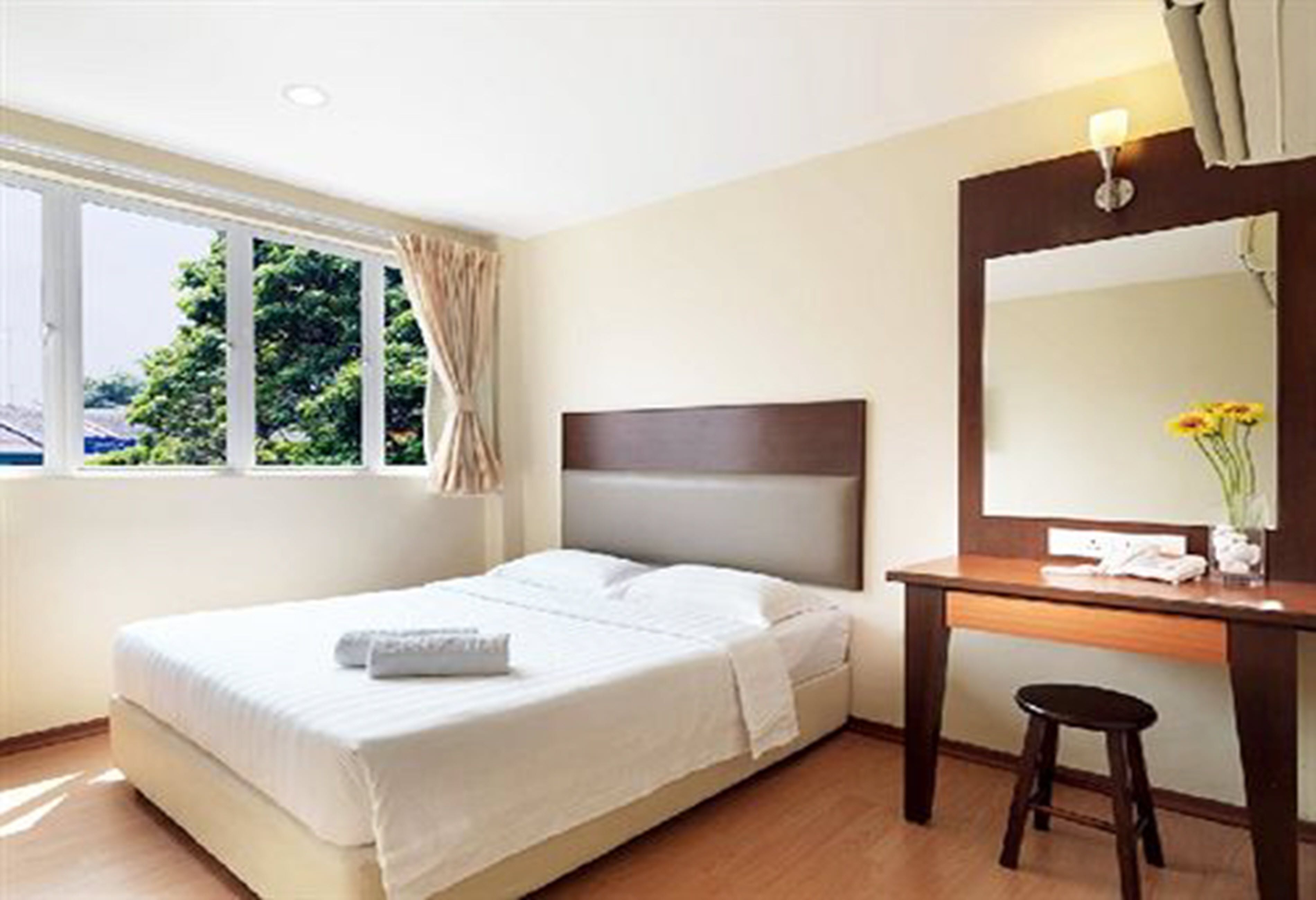 Una habitación de hotel con una cama, un escritorio y un ventanal grande.