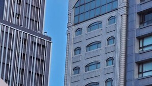 A multi-story building with a prominent sign at the top. - KDM Hotel (Taipei)