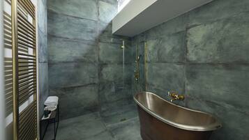 A modern bathroom with a freestanding bathtub, a glass-enclosed shower, and a towel rack with folded towels.