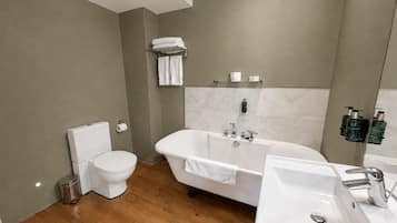 A modern bathroom with a toilet, bathtub, and sink.